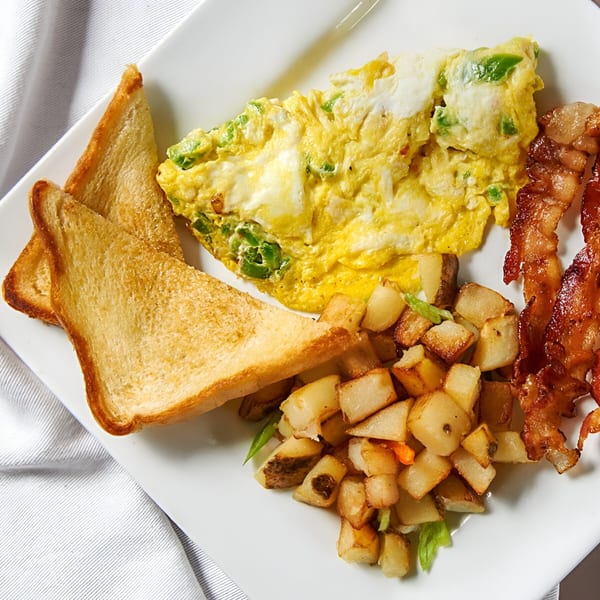 Jamerican Kitchen Cafe's breakfast plate with omelet, home fries, bacon, and toast.